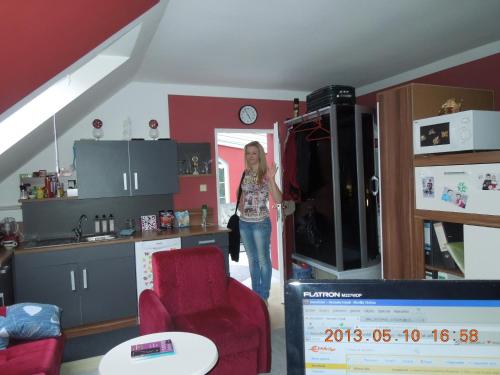 a woman standing in a kitchen with a refrigerator at Homestay Kuchařovice in Kuchařovice