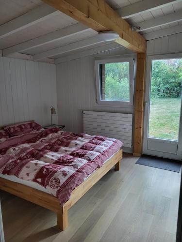 a bedroom with a large bed in a room with windows at Rhône Cottage 4 in Noville