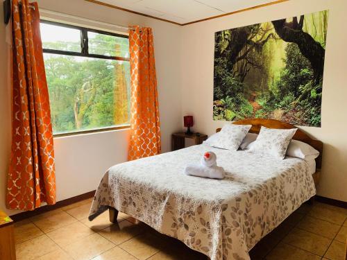 a bedroom with a bed with a duck toy on it at Globi Lodge #4 in Monteverde Costa Rica