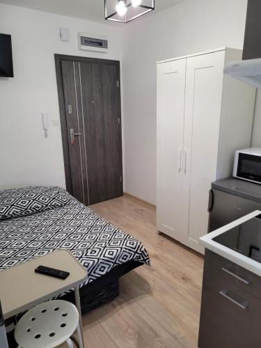 Habitación pequeña con cama y cocina en Kobierska 8 Mieszkanie 2, en Krotoszyn