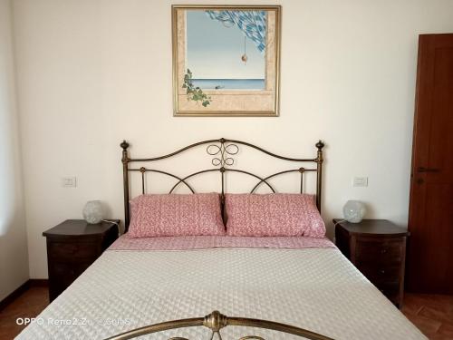 1 dormitorio con 1 cama con una foto en la pared en A Casa di Marti, en Loreto