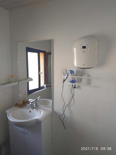 La salle de bains est pourvue d'un lavabo et d'un sèche-cheveux mural. dans l'établissement appartement centre ville du Boulou pour 2 adultes-2 enfants- check in 17h-21h--juillet-aout reservation de 7 jours mini, au Boulou
