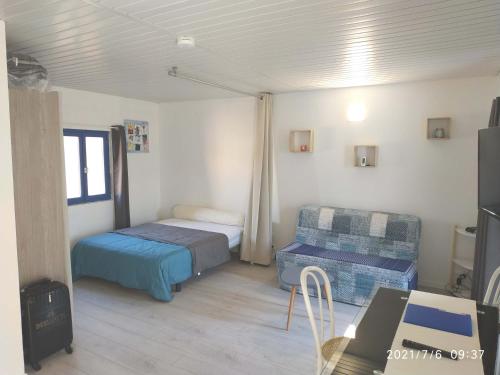 Kleines Zimmer mit einem Bett, einem Tisch und einem Schreibtisch. in der Unterkunft appartement Le Boulou centre ville pour 2 adultes-2 enfants- check in 17h-22h location curistes et vacanciers Juillet-aout réservation d'une semaine minimum-Reserva de julho a agosto de no mínimo uma semana in Le Boulou