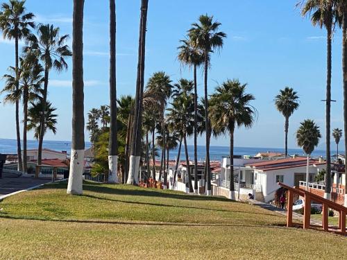 a park with palm trees and the ocean in the background at Beachfront Bungalow Rosarito Beach in Rosarito