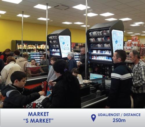a group of people standing around a store checkout at Apartman Stevan in Pirot