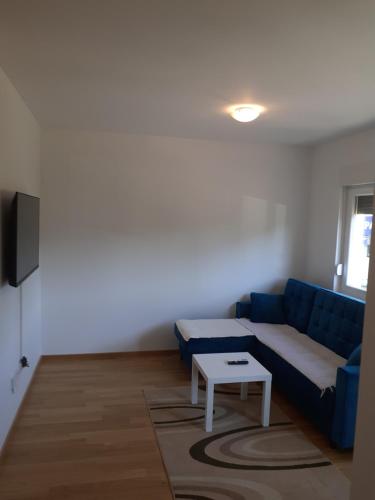 a living room with a blue couch and a table at Apartman kod Brke 20 A Bulevar Vojvode Živojina Mišiča in Banja Luka