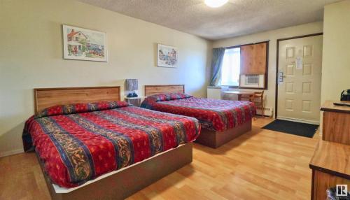 Kings Court Motel في Cold Lake: غرفه فندقيه سريرين في غرفه