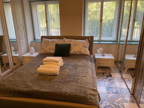 una camera da letto con un letto grande con due asciugamani sopra di Völgyhíd Vintage Apartman a Pusztaszemes