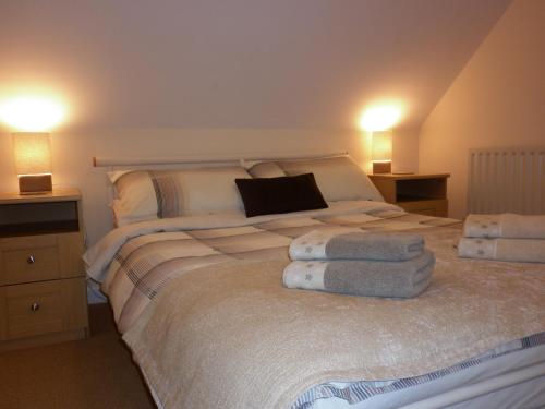 1 dormitorio con 1 cama grande y toallas. en Country Garden House Holiday Homes, en Ballymoney