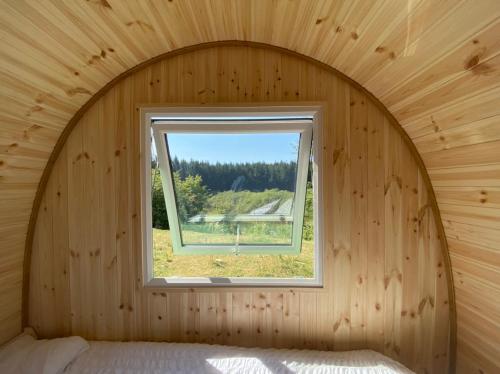 Zimmer mit Fenster in einem Holzzimmer in der Unterkunft Lakeside Eco Pod in Oswestry