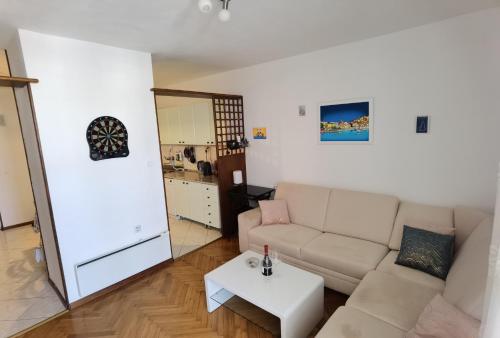 ein Wohnzimmer mit einem Sofa und einem Tisch in der Unterkunft T-star, 2-bedroom apartment with magnificent beach view in Split