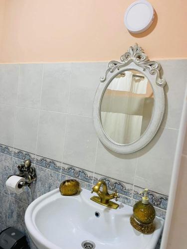 a bathroom with a sink and a mirror on the wall at Villa Gardenia Ureki in Ureki