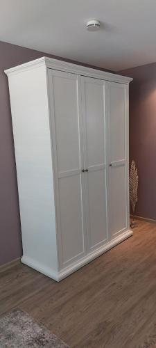 a white cabinet in the corner of a room at le cadeau in Wincheringen