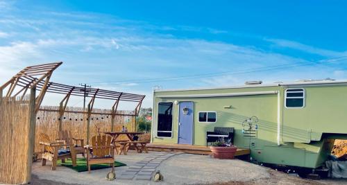 remolque verde con mesa y patio en Rustic Farm meadow stay, en Temecula