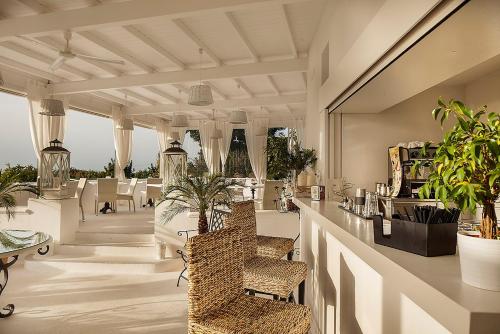 a lobby with a bar with chairs and plants at Tenuta Del Poggio Antico in Ischia