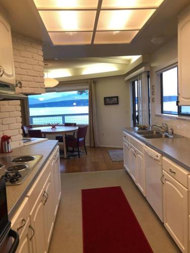 a kitchen with white appliances and a dining room with a table at Waterfront, Sunsets and Mountains in Port Townsend