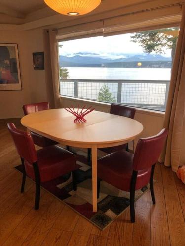 a table and chairs in a room with a large window at Waterfront, Sunsets and Mountains in Port Townsend