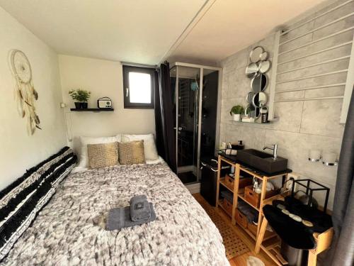 1 dormitorio con 1 cama y lavamanos. en La Cabane Enchantée - Votre Pause Arborée, en La Bruyère