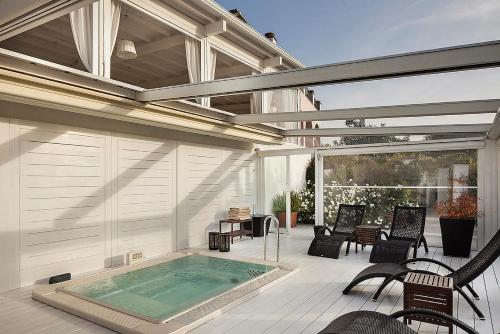 a patio with a hot tub and chairs on a deck at Tenuta Del Poggio Antico in Ischia