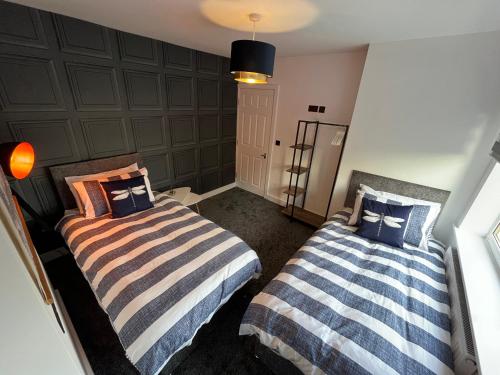 two beds sitting next to each other in a room at Modern three bedroom home, Hoyland, Barnsley in Hoyland Nether