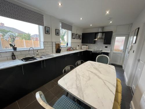 a kitchen with a marble table and chairs at Modern three bedroom home, Hoyland, Barnsley in Hoyland Nether