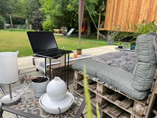 a laptop computer sitting on a table next to a chair at La Cabane Enchantée - Votre Pause Arborée in La Bruyère