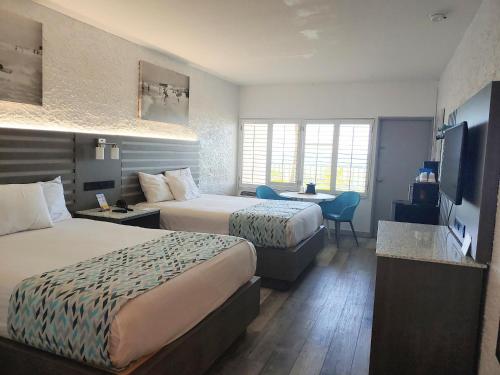 Habitación de hotel con 2 camas y escritorio en Casa Loma Panama City Beach - Beachfront, en Panama City Beach
