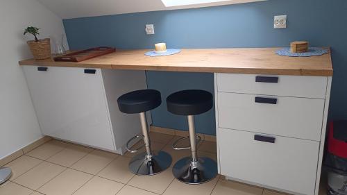 a kitchen with a counter with two stools and a desk at Komfortowe Noclegi in Szałsza