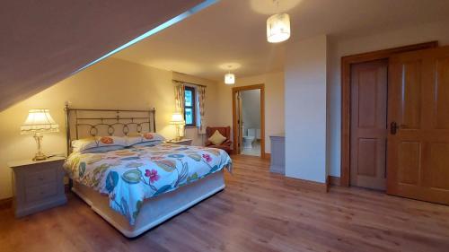 een slaapkamer met een groot bed en een trap bij Drumsallagh View in Loughbrickland
