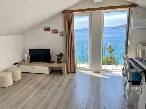 sala de estar con TV y ventana grande en Apartments Milano, en Herceg-Novi