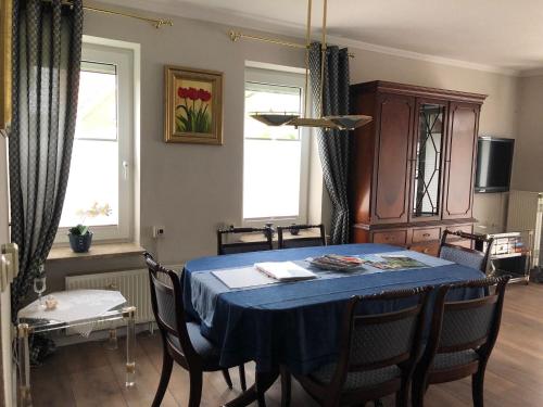 a dining room with a blue table and chairs at Deichblick in Brunsbüttel
