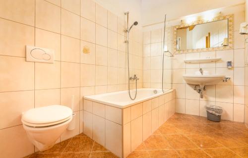 uma casa de banho com uma banheira, um WC e um lavatório. em Hotel Traube em Fliess