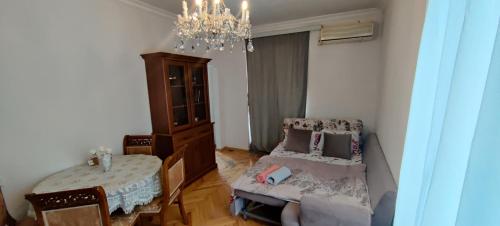 a living room with a bed and a chandelier at Budget One Room Apartment in Baku