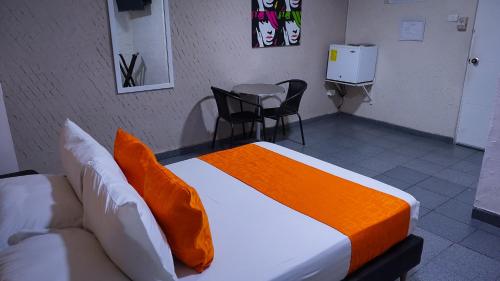 a bedroom with a bed and a table and chairs at Hotel Casa Boston Inn by Finerh in Barranquilla