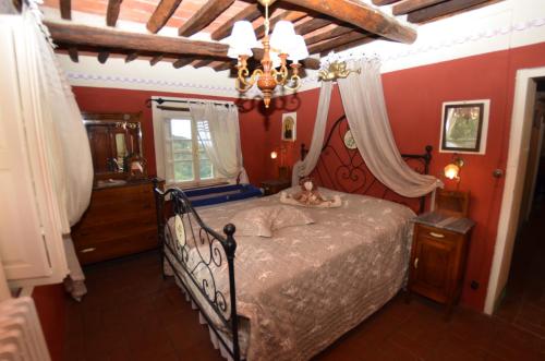 a bedroom with a bed and a chandelier at Borgo Bucatra Buonvento in Chiatri