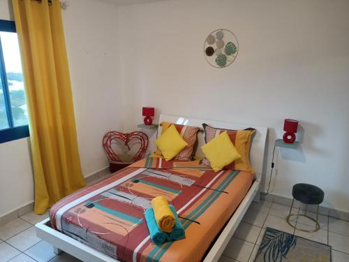 una camera da letto con un letto e asciugamani di Entre Mer et Montagne, appartement climatisé, vue mer, WIFI a Sainte-Marie