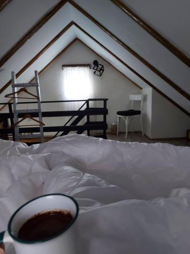 a bed with a cup of coffee on top of it at The Village House Zlatar in Nova Varoš
