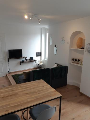 - un salon avec une table et un canapé dans l'établissement Cosy T2 31m2 - Centre-Ville Dijon - Gare et Darcy, à Dijon