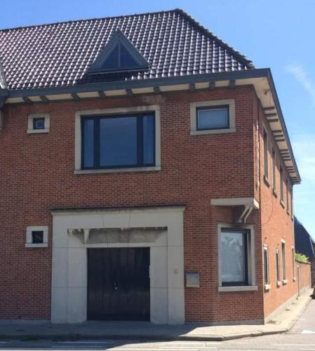 a red brick building with a garage at Vakantiehuis Clarys in Veurne