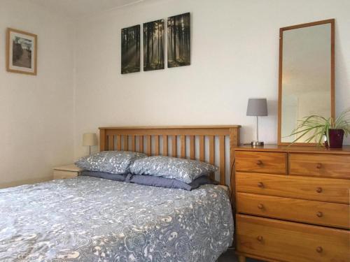 a bedroom with a bed and a dresser and a mirror at Wonderfully Cosy 3BD Home in the Heart of Cornwall in St Austell