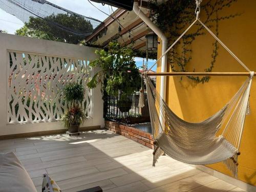 a hammock hanging on a patio with a fence at Airport SJO Residence - Edward & Familia Inn in Alajuela City