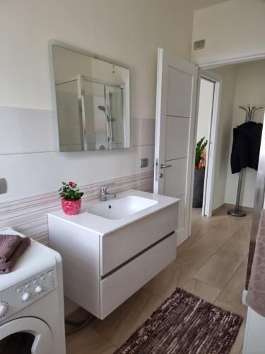 a white bathroom with a sink and a mirror at Benny's House in Alghero