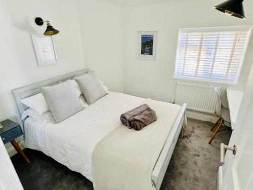 a bedroom with a white bed with a towel on it at The Terrace - Tankerton in Kent
