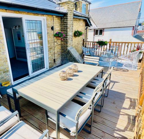 a white table and chairs on a deck at The Terrace - Tankerton in Kent