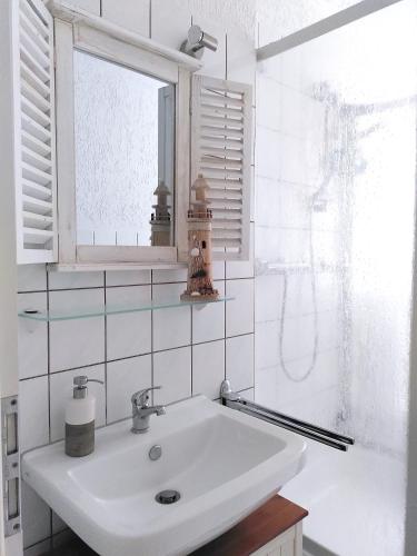 a white bathroom with a sink and a window at Usedoms Kleines Ostseeglück #1 in Peenemünde bis 4 Personen, Zuganreise möglich in Peenemünde