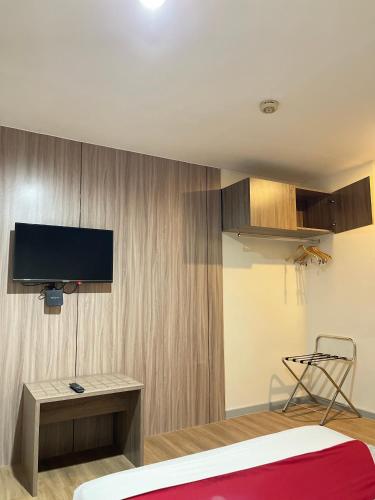 a room with a bed and a tv on a wall at Anex Hotel near US Embassy in Manila