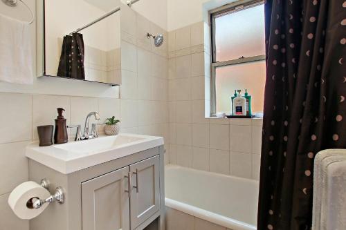 a bathroom with a sink and a bath tub at Deluxe 1BR Apartment in Ravenswood - Campbell 3 in Chicago