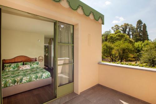 a balcony with a bed and a glass door at The Greenhouse Luxury Villa on Lake Como in Como