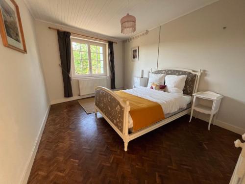 een slaapkamer met een bed en een raam bij La Maison Pourpre in Vélines