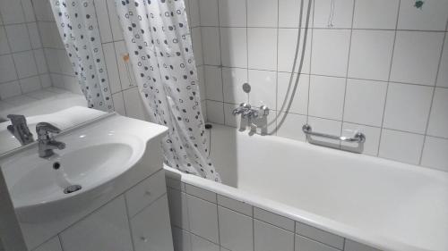 La salle de bains blanche est pourvue d'un lavabo et d'une douche. dans l'établissement Kämen 2 Zimmer, à Stuttgart